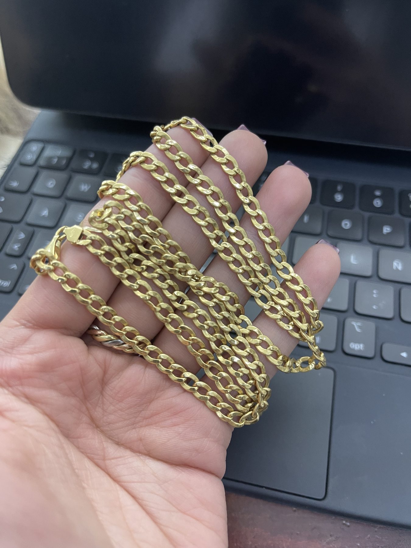 Cadenas gruesas de oro exhibidas en la mano
