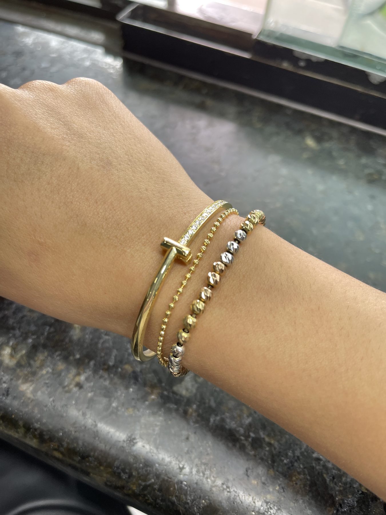 Pulseras de oro con cruces y cuentas sobre la muñeca